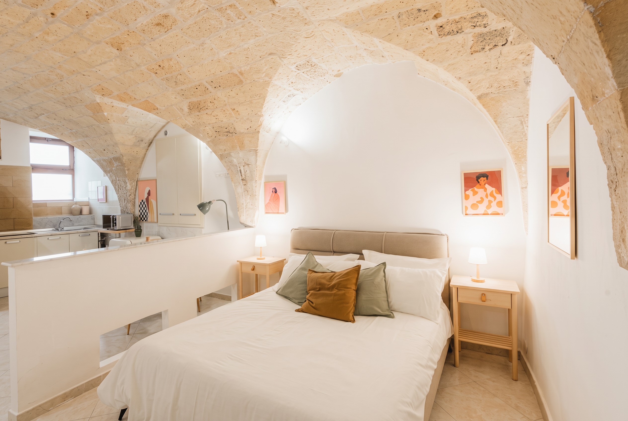 Sleeping area beneath pale Lecce-stone arches