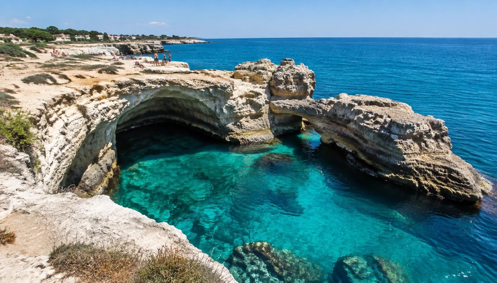 Vue panoramique sur les falaises de calcaire blanc et les eaux turquoise de Torre Sant'Andrea dans le Salento.